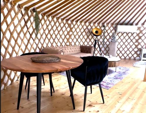 a room with a table and chairs in a yurt at Glamping ve vinici - Jurty zijumarcipan - Jižní Morava in Blučina