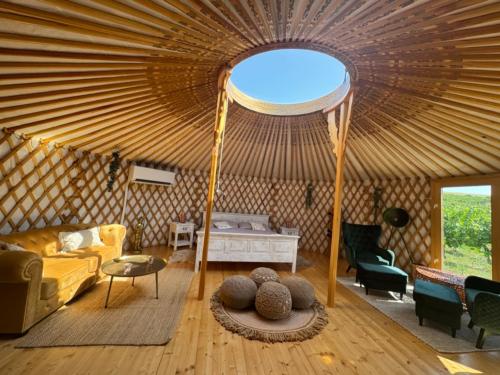 a room with a yurt with a couch and a bed at Glamping ve vinici - Jurty zijumarcipan - Jižní Morava in Blučina