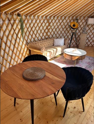 a room with a table and a couch in a yurt at Glamping ve vinici - Jurty zijumarcipan - Jižní Morava in Blučina