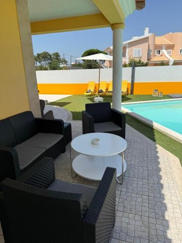 a patio with a table and chairs and a pool at Pool, BBQ & Soccer Villa in Aroeira