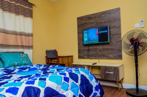 a bedroom with a bed and a flat screen tv at Shortlet Apartment Magodo Phase1 in Iseri-Oke