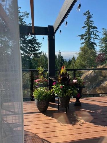 a deck with two potted plants on it at Serene Forest Retreat in Sooke