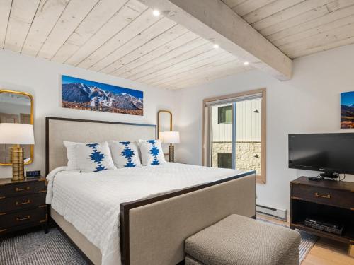 a bedroom with a large bed and a television at Lift One Condominiums - 1, 2, 3 Bedroom Units Adjacent To Downtown Aspen in Aspen