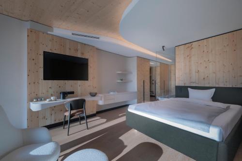 sypialnia z łóżkiem i telewizorem na ścianie w obiekcie Buff Hotel & Resort Konstanz w Konstancji