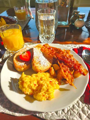 a plate of food with fried eggs and bacon at Riverside Inn Bed and Breakfast in Warsaw
