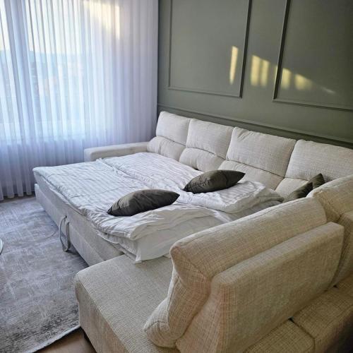 a white couch with two pillows on it in a living room at Apartment Sarajevo Airport1 in Sarajevo