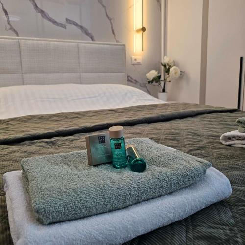a hotel room with a bed with a towel and a bottle of medicine at Apartment Sarajevo Airport1 in Sarajevo