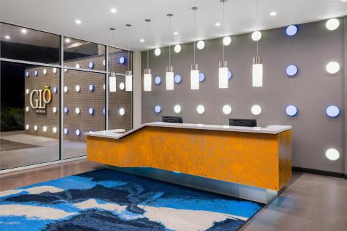 a lobby with a reception desk and mirrors at GLō Best Western Enid OK Downtown - Convention Center Hotel in Enid