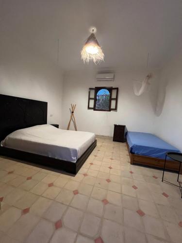 ein Schlafzimmer mit zwei Betten und einem Kronleuchter in der Unterkunft Dar Talat in Tahannaout