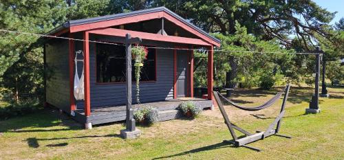 a smallshed with a hammock in front of it at Lighthouse Benki in Užava