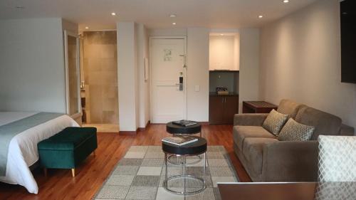 a bedroom with a bed and a couch and a living room at Hotel Portón de la Cabrera in Bogotá