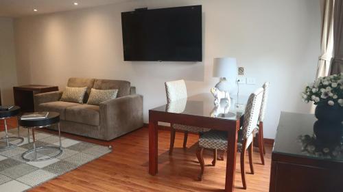 a living room with a table and chairs and a couch at Hotel Portón de la Cabrera in Bogotá