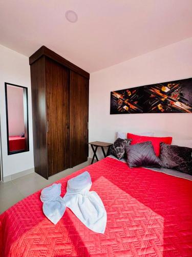 a bedroom with a red bed with two towels on it at Villas del mar in Cartagena de Indias
