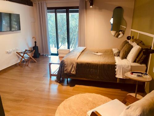 a bedroom with a bed and a living room at Bangalô 2 Rota do Vinho São Roque in São Roque