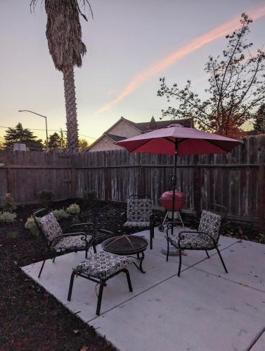 a patio with a table and chairs and an umbrella at Zesty Studio & Pet Friendly Yard in Modesto