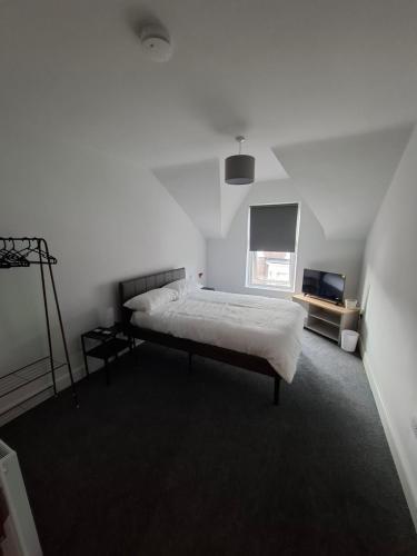 a white bedroom with a bed and a window at Alice house in Sunderland
