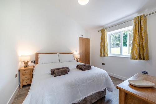 ein Schlafzimmer mit einem weißen Bett mit zwei Handtüchern darauf in der Unterkunft Little Mead in Littleham