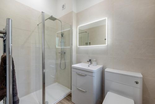 ein Badezimmer mit Dusche, Toilette und Waschbecken in der Unterkunft Little Mead in Littleham