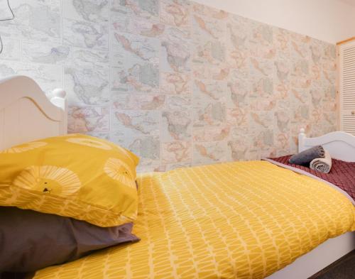 a bedroom with a bed with a yellow comforter at Seren Fach in Barmouth