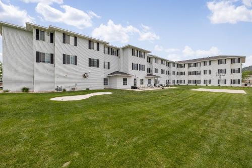 a large building with a green yard in front of it at GrandStay Residential Suites Rapid City in Rapid City