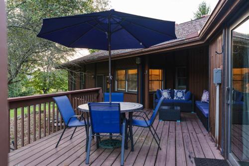 a table and chairs on a deck with an umbrella at Liberty Lodge Pool & Hot Tub Game Room BBQ in McArthur