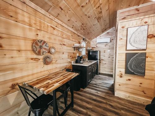 a log cabin kitchen with a wooden wall at Cabin #1 Studio With Kitchenette in Hartwell