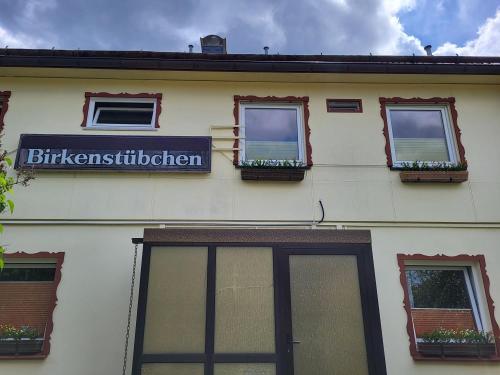 a building with windows and a sign on it at Birkenstübchen in Lautenthal