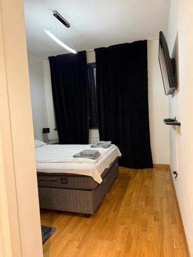 a bedroom with a bed and a black curtain at Belgrade Waterfront apartments in Belgrade
