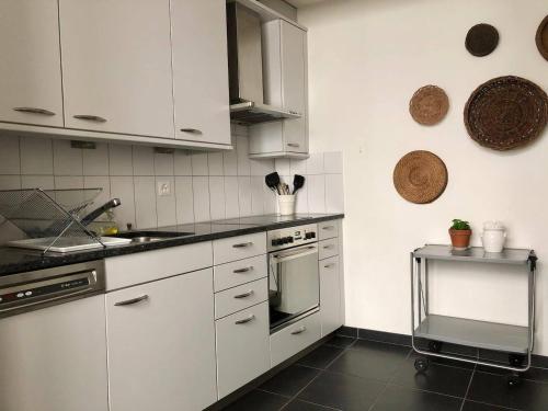 a kitchen with white cabinets and a stove top oven at Steps To Best Bern Sites And Lots Of Space Too! in Bern
