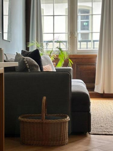 a living room with a black couch and a basket at Steps To Best Bern Sites And Lots Of Space Too! in Bern