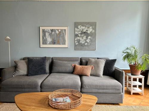 a living room with a gray couch and a table at Steps To Best Bern Sites And Lots Of Space Too! in Bern