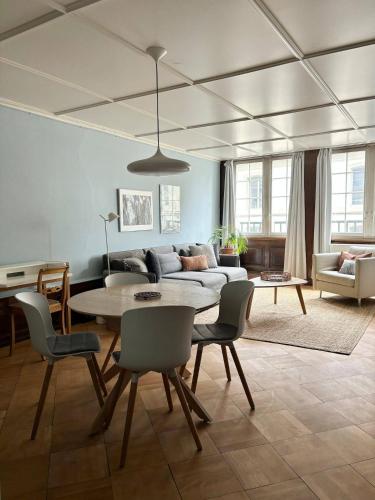 a living room with a table and a couch at Steps To Best Bern Sites And Lots Of Space Too! in Bern