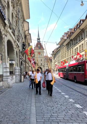 a group of people walking down a street holding flags at Steps To Best Bern Sites And Lots Of Space Too! in Bern