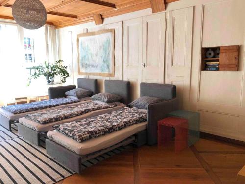 a living room with four beds and a couch at Steps To Bern's Best Historic Sites! in Bern