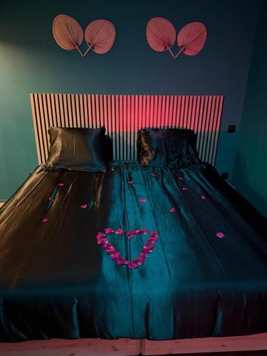 a bed with a blue comforter with a heart on it at Love room, Le 827 