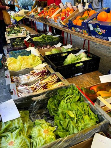 a market filled with lots of vegetables and fruits at Steps To Bern's Best Historic Sites! in Bern