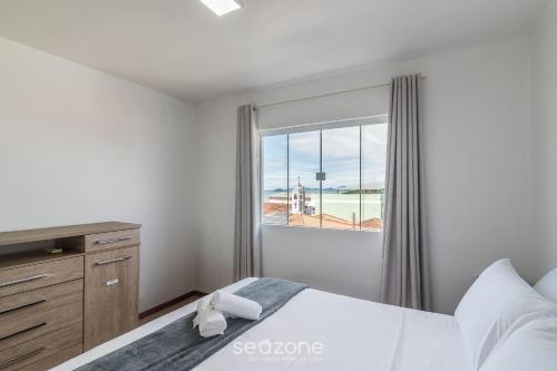 a bedroom with a bed and a window at Apto Vista Mar Lateral a 120m da Praia EEI0303 in Itajubá