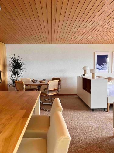 a living room with a couch and a table at Sweet Retreat W Dreamy Lakeviews in Aeschlen ob Gunten