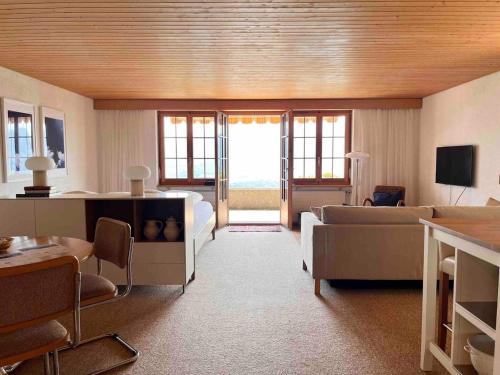 a living room with a couch and a table at Sweet Retreat W Dreamy Lakeviews in Aeschlen ob Gunten