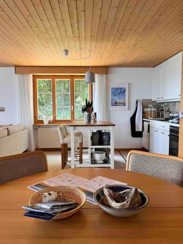 a kitchen and living room with a wooden table with a table at Sweet Retreat W Dreamy Lakeviews in Aeschlen ob Gunten