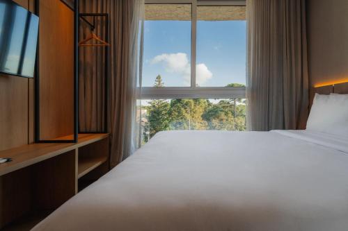 Ένα ή περισσότερα κρεβάτια σε δωμάτιο στο Golden Tulip Canela