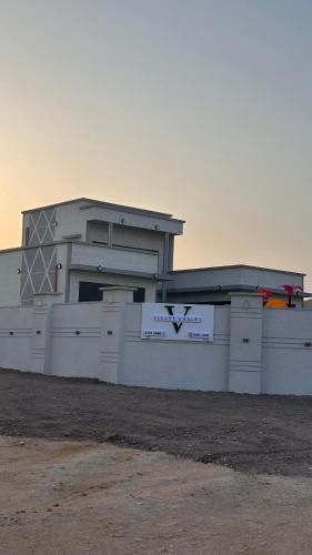 a white building with a sign in front of it at Violet Chalett in Jalan Bani Buali