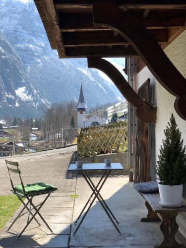 a patio with a table and a chair and a church at Studio With The Stunning Valley Views in Lauterbrunnen