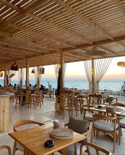 a restaurant with tables and chairs and a view of the ocean at See your sea in Ras Sedr