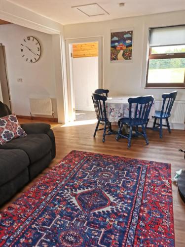 a living room with a couch and a table with chairs at Nomad's Cottage and Yurt 