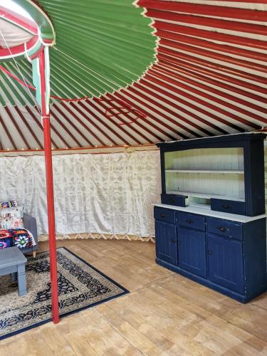 a living room with a television in a tent at Nomad's Cottage and Yurt 