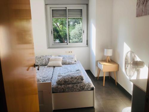 een kleine slaapkamer met een bed en een raam bij Standing Apartment Barcelona Forum in Sant Adria de Besos