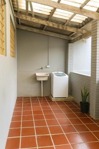 a bathroom with a sink and a toilet on a tiled floor at Casa Espaçosa 3quartos Piscina Churrasqueira Estacionamento in Canoas
