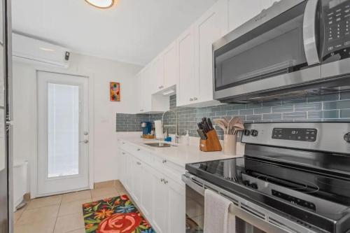 a kitchen with a stove and a microwave at Mermaid Tropical Villa in Largo