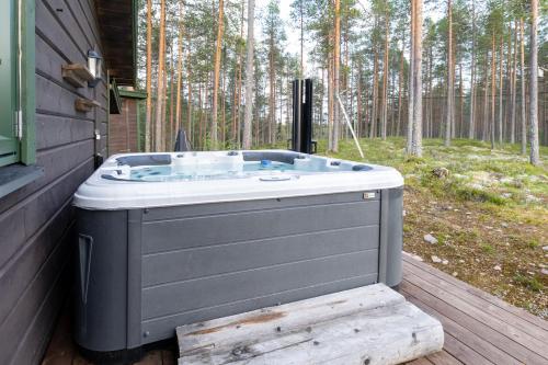 a hot tub sitting on a deck next to a forest at Trysil Hyttekos & Panorama in Trysil
